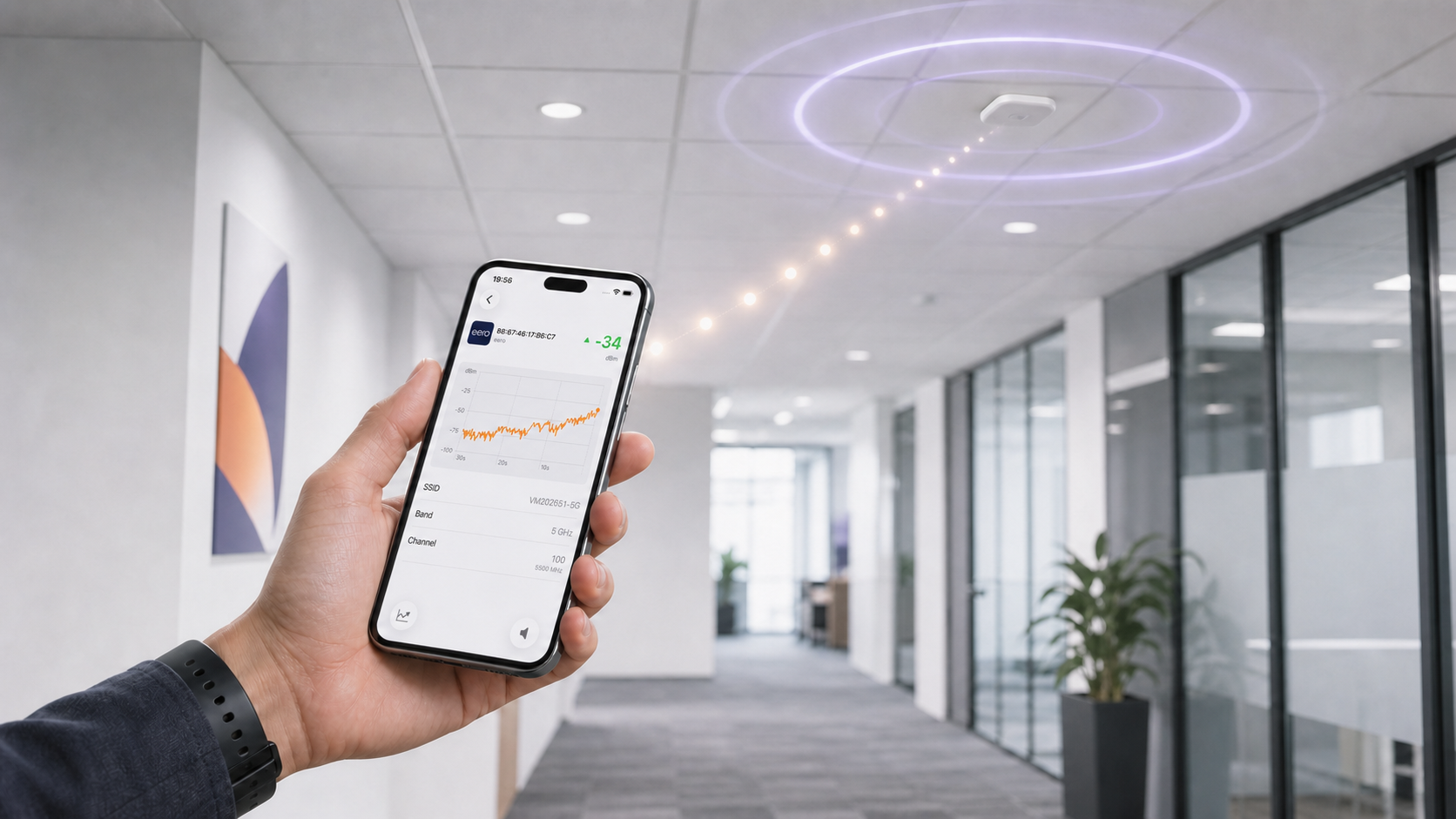 Network professional using AP Finder’s live RSSI graph on an iPhone to locate a ceiling-mounted Wi-Fi access point.